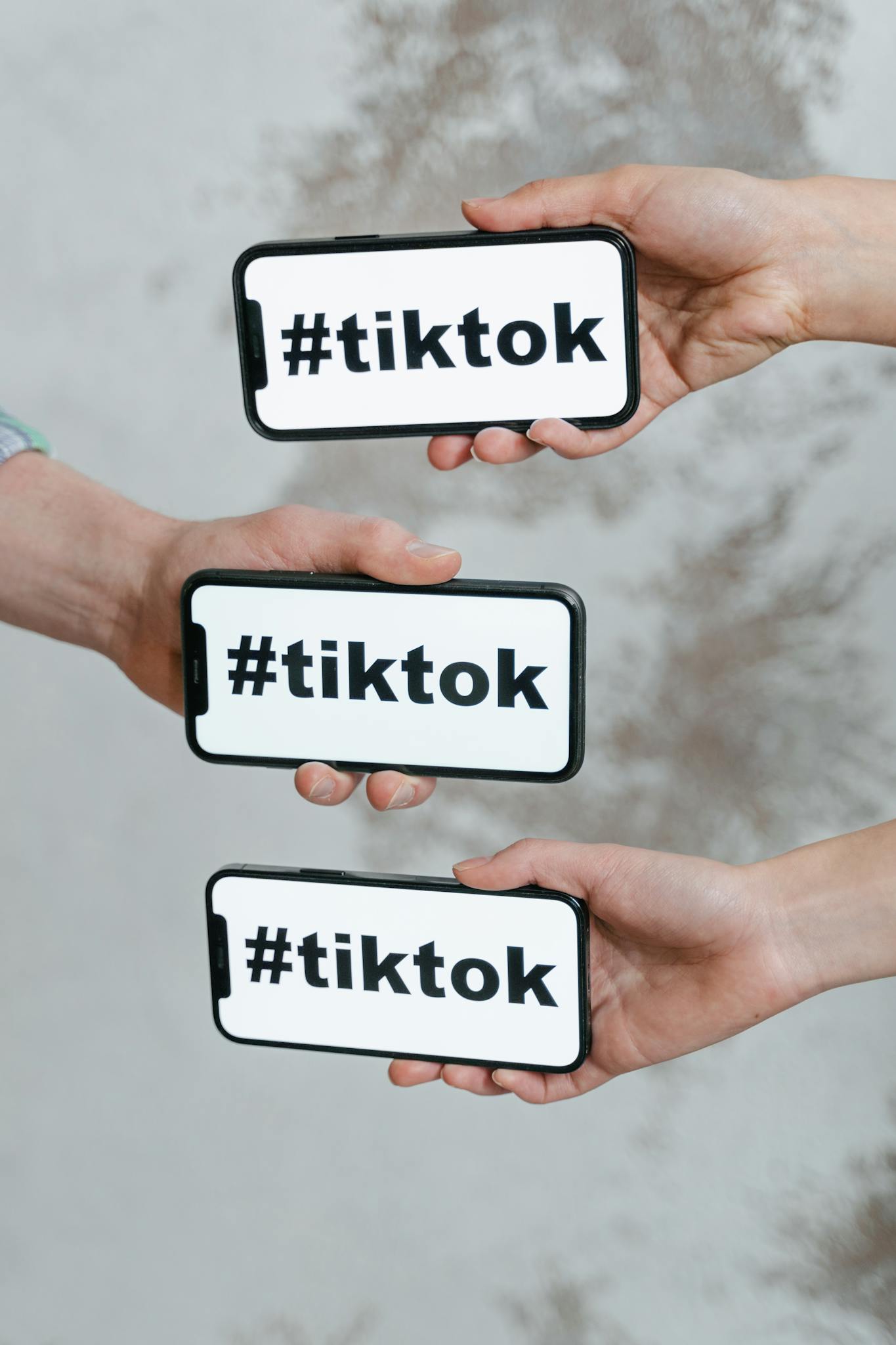 Hands Holding Smartphones Displaying Tiktok Hashtag Emphasizing